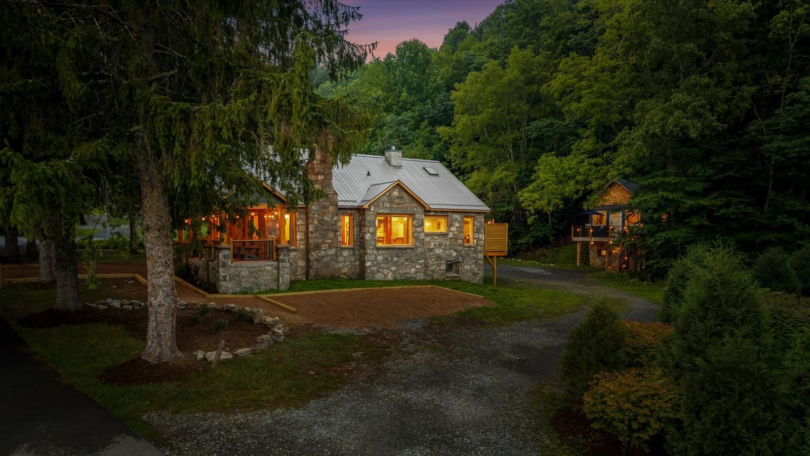 Stone cottage lit at dusk